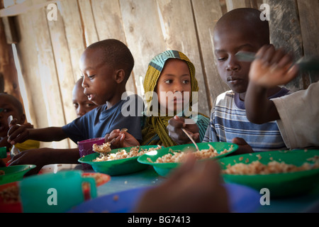 Kinder erhalten in Mererani, Tansania, die weltweit einzige Quelle der Tansanit Mahlzeiten in einer Küche. Stockfoto