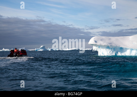 Expedition Kreuzfahrt-Passagiere genießen ein Zodiac Kreuzfahrt ab Pleneau Island, Antarktis. Eisberg, geformt wie ein Krokodil Kiefer Stockfoto