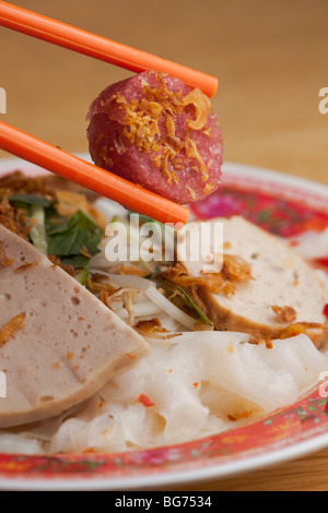 Bánh ướt, eine vietnamesische Reis Nudelgericht serviert mit Cha Lụa (vietnamesische Wurst), Nem Chua und andere Gewürze in Saigon. Stockfoto