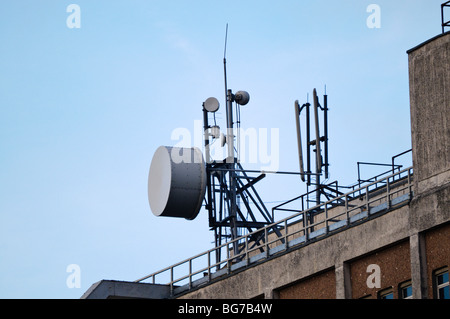 Mikrowellenantenne auf eine Telefonzentrale neben Mobilfunknetz Antennen. Stockfoto