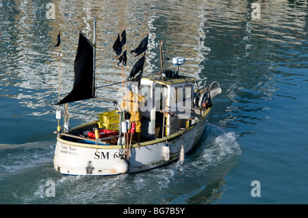 Ein Fischer in seinem kleinen Fischerboot zum Yachthafen in England Segeln. Stockfoto