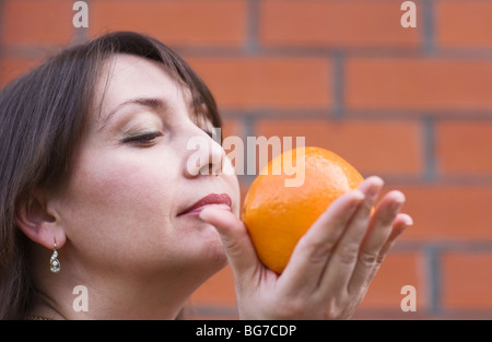 Erwachsene Frau mit Orange, close-up Stockfoto