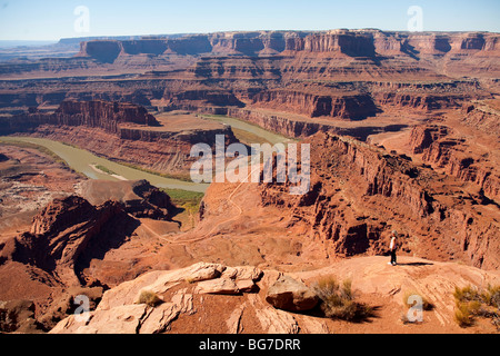 Eine aktive ältere Frau schaut über den Colorado River aus Dead Horse Park, angrenzend zum Canyonlands National Park in Moab, Utah Stockfoto