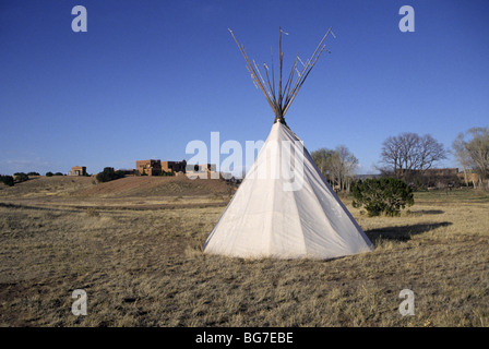 Ein Indianer-Tipi in der Nähe von einem großen Adobe-Haus in der Wüste des Gaiisteo Beckens des nördlichen New Mexico. Stockfoto