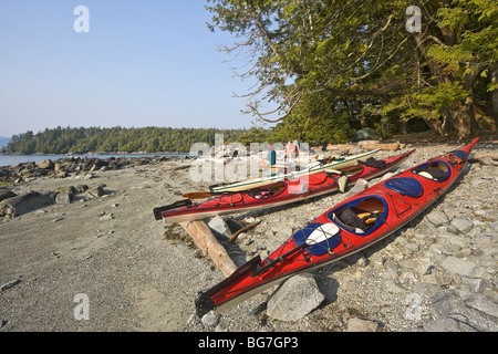 Camper sitzen mit ihren Kajaks am Strand auf ihre Wildnis Zelt Campingplatz auf Willis Insel vor Vancouver Island, Kanada Stockfoto