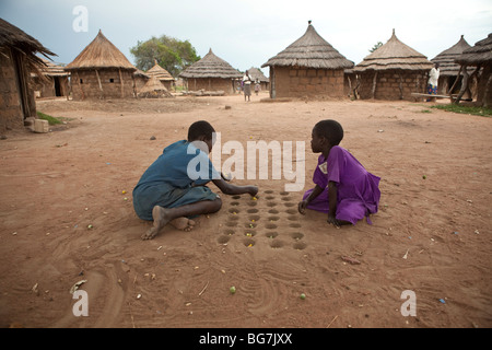 Mädchen spielen im Flüchtlingslager Acowa, Amuria District, NE Uganda das Brettspiel Mankala (oder Mancala). Stockfoto
