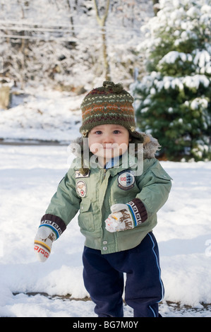 11 Monate altes Hispanic junge spielt im frisch gefallenen Schnee in seinem Vorgarten mit seiner Mutter.  Bild ist Modell veröffentlicht. Stockfoto