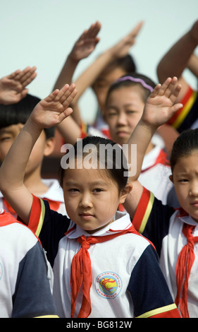 Chinesische Schulmädchen begrüssen die Flagge, Beijing, China. Stockfoto