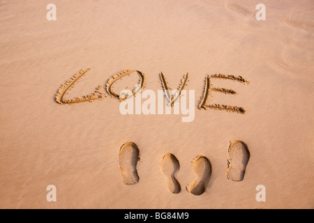 Zwei Paare von Platzbedarf und Liebe geschrieben in den Sand am Strand Stockfoto