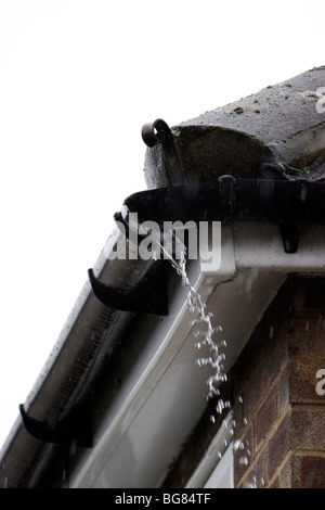 REGENWASSER TRITT AUS EINER DEFEKTEN KUNSTSTOFFRINNE AUS Stockfoto