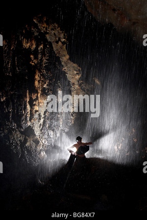 Ein Höhlenforscher trotzt der Kälte und Nässe, um tief unter der Erde in Mulu Nationalpark, Sarawak, Borneo Wasserbehälter aufzufüllen. Stockfoto