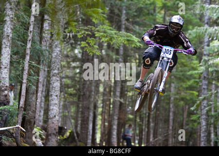 Ein downhill-Mountainbike Fahrrad Racer fliegt durch einen Teil des Waldes. Stockfoto