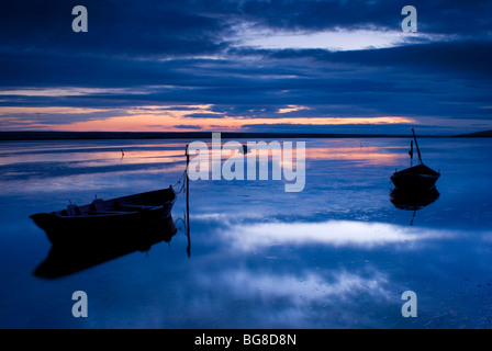 Boote bei Sonnenuntergang am Chesil Beach, Dorset UK Stockfoto