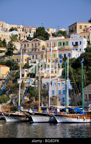 Yachten vor bunten traditionellen Häusern im Hafen von Symi Insel Symi, Griechenland Stockfoto