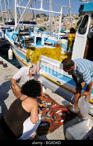 Kaufen Fische vom Kutter auf Symi Stadt, Insel Symi, Griechenland Stockfoto