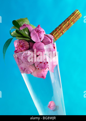 Rosa Lotus Blumenknospen gebunden in einen Blumenstrauß in einer Vase auf blauem Hintergrund Stockfoto