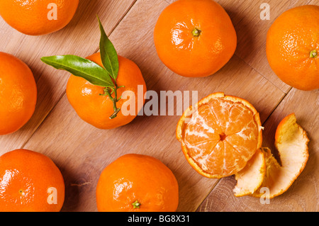 Draufsicht von Clementine Früchte, eine mit Blättern und eine Hälfte geschält Stockfoto