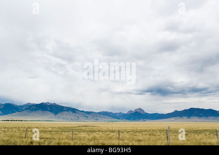 Berg, landwirtschaftliche Flächen und Himmel gesehen vom Highway 287 in Madison County, Montana, USA. Stockfoto