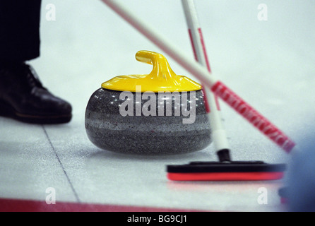 Lockenwickler fegt Weg der Curling-Stein Stockfoto