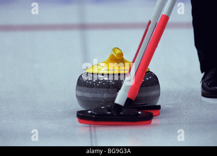 Lockenwickler fegt Weg der Curling-Stein Stockfoto