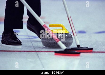 Lockenwickler fegt Weg der Curling-Stein Stockfoto