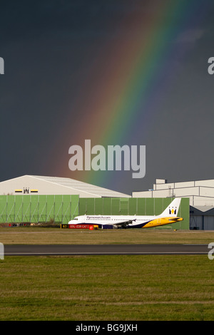 Monarch Airlines Airbus A320 Rollen vor ein Regenbogen am Manchester International Airport Stockfoto