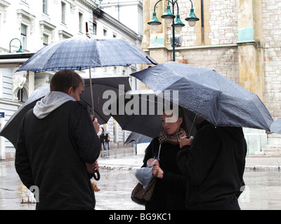 Bosnien-Sarajevo-junge Menschen im Regen im Chat und bergende unter Sonnenschirmen Stockfoto