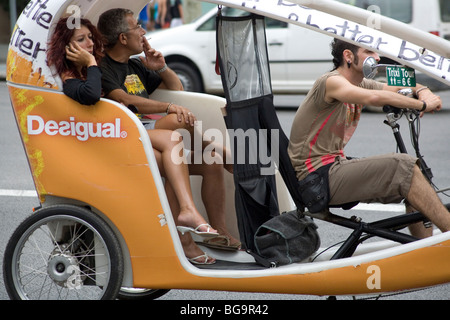 GELANGWEILTE TOURISTEN, RAUCHEN, RIKSCHA, BARCELONA: Gelangweilte Touristen in einer Fahrrad-Taxi-Rikscha eine rauchende im Zentrum von Barcelona Spanien Stockfoto