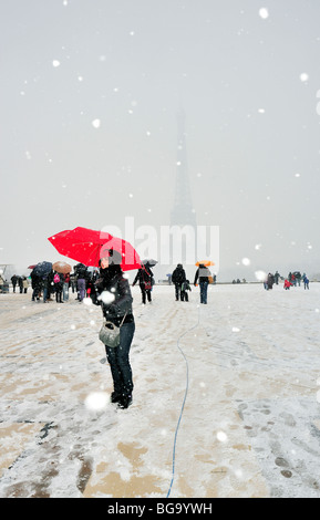 Paris, Frankreich, Winter große Menschenmenge zu Fuß im Schneesturm, Touristen mit Sonnenschirmen, Besuch des Eiffelturms am Place Trocacadero Stockfoto