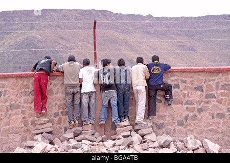 Jungen im Teenageralter eine Kletterwand um ein Fussball Spiel, Chivay, Arequipa Bezirk, Anden, Peru, Südamerika ansehen Stockfoto