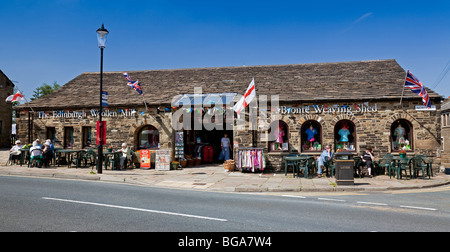 England, West Yorkshire, Haworth, North Street mit dem Brontë Weaving Shed und der Edinburgh Woollen Mill Stockfoto