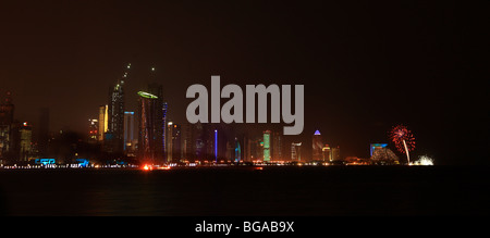 Ein Feuerwerk explodiert über das Sheraton-Hotel in Doha wie Rauch aus der Nationalfeiertag Display Drifts vorbei an den Türmen in West Bay Stockfoto