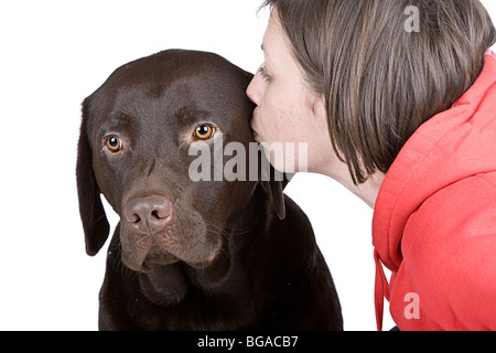 Schuss einen 30er Jahre weiblich küssen ihr Chocolate Labrador-Haustier Stockfoto