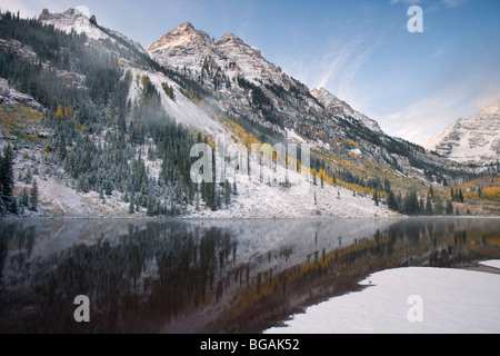 Berge mit Schnee bedeckt und rund um die Maroon Lake (CO) mit Eisbildung im Vordergrund. Klaren Morgenhimmel Stockfoto