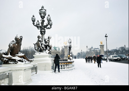 Paris, Frankreich, Wintermenschen im Schneesturm, Touristen, die auf der Brücke „Pont Alexandre III“ spazieren, Pariser Straßenszene, Vintage Outdoor Stockfoto