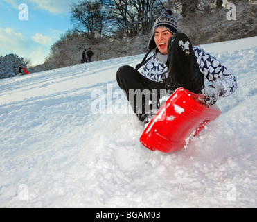 Teenager im Schnee Rodeln. Stockfoto