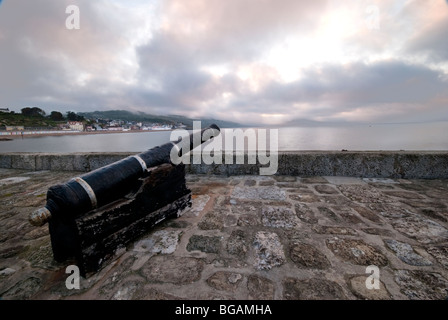 Kanone auf der Hafenmauer bei Tagesanbruch in Lyme Regis Stockfoto