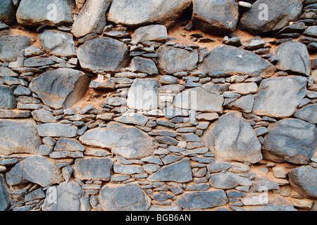 Hohe Mauer mit verschiedenen großen Felsen und Schlamm um Saline in der Nähe Küste in Spanien Stockfoto