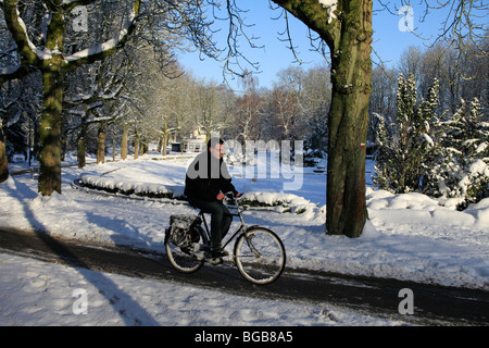 Mann, Radfahren durch verschneite Winterlandschaft mit Schnee Stockfoto