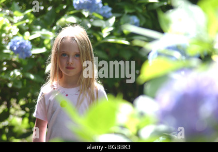 Lizenzfreie kostenlose Foto von junge Mädchen Portrait als sie steht bei Sonnenschein im Garten der Familie London UK Stockfoto