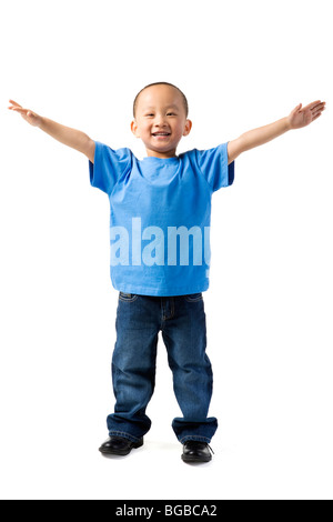 Kleiner Junge steht mit seiner Arme ausbreiten Stockfoto