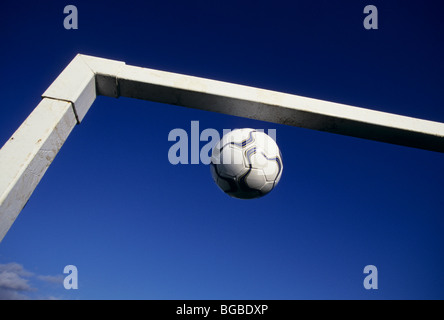 Fußball in der oberen Ecke ein Torpfosten Stockfoto