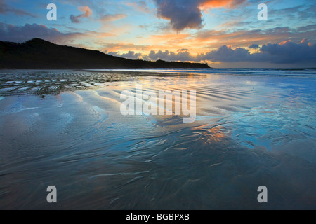 Dramatische Wolken und Sonnenuntergang über dem Strand entlang Cox Bay in der Nähe von Tofino, einem Übergangsbereich des Clayoquot Sound UNESCO Biosphäre R Stockfoto