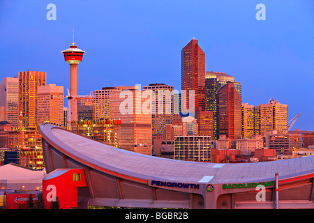 Der Saddledome mit Hochhäusern und dem Calgary Tower im Hintergrund bei Sonnenaufgang, Stadt von Calgary, Alberta, Kanada. Stockfoto