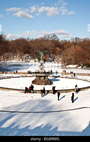 verschiedene kleine Gruppen von Menschen versammeln sich um Bethesda Fountain & zugefrorenen See an einem sonnigen Wintertag im Central Park in New York Stockfoto