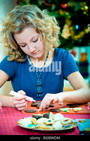 Weihnachten backen, 13 jährige Mädchen Dekoration Weihnachtsplätzchen Stockfoto