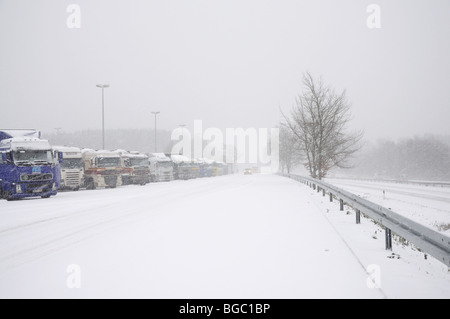 LKW auf einem Parkplatz auf einer deutschen Autobahn im winter Stockfoto