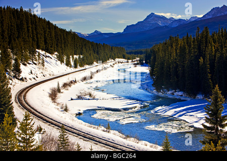 Bow River im Banff National Park, kanadischen Rocky Mountains, ein Winter gesäumt Wicklung Gleisanlagen neben Schnee und Eis Stockfoto