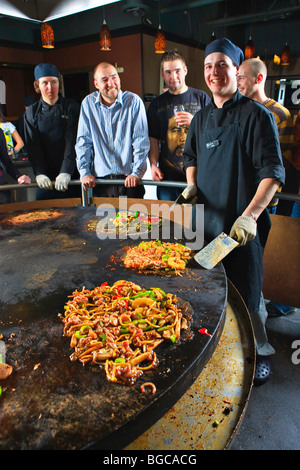 Koch, Zubereitung von Mahlzeiten, während Gäste versammeln, Mongolie World Famous hineinschütten Grillrestaurant in Whistler Villa ansehen Stockfoto