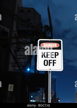Gefahr - zu halten Off Schild mit einem Industriegebäude im Hintergrund Stockfoto